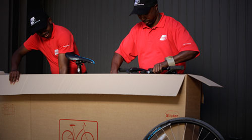AGS Movers staff busy packing bicycle in a customised carton for moving.